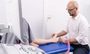 Ortopeda wykonuje badanie USG stopy pacjentki.
