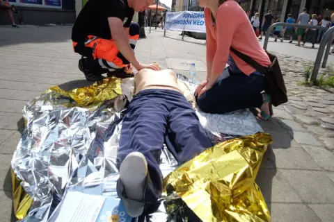 Ćwiczenia pierwszej pomocy: pozycja czterokończynowa przy omdleniu na kocu termoizolacyjnym.