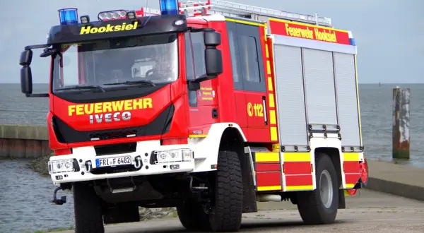 Czerwony wóz strażacki Iveco z napisem "Feuerwehr Hooksiel" i numerem 112. To jeden z rodzajów wozów strażackich, gotowy do akcji.
